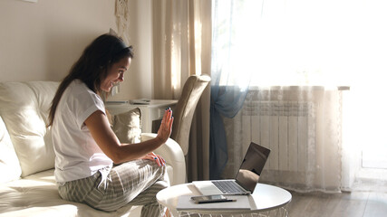 Young woman wears headset conference calling on laptop talks with online teacher studying, working from home. Lady student learning using computer webcam chat makes notes. Distance education concept