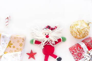 funny toy santa claus, gift boxes, star and christmas ball on a white background. Copy space.