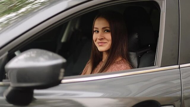 driving, safety and people concept - Young woman in car. Auto as present or gift at birthday. Happy girl in a city with her new automobile holding keys. 4k