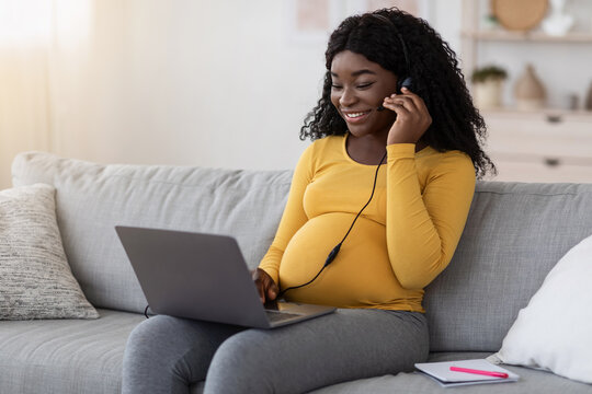 Cheerful african american pregnant woman having videocall at home