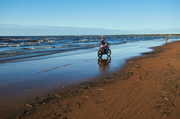motorcyclist rides on the beach of the gulf of finland