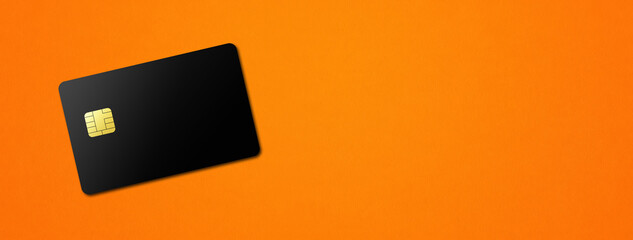 Black credit card on orange background