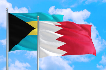 Bahrain and Bahamas national flag waving in the windy deep blue sky. Diplomacy and international relations concept.