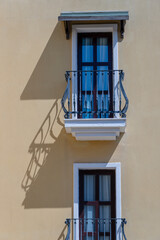 Fototapeta na wymiar Windows with balcony on building facade with cast iron ornaments , Turkey