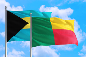 Benin and Bahamas national flag waving in the windy deep blue sky. Diplomacy and international relations concept.
