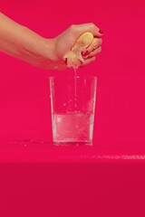 hand holding a glass of water and lemon 