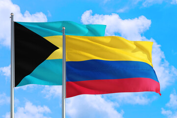 Colombia and Bahamas national flag waving in the windy deep blue sky. Diplomacy and international relations concept.