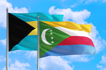 Comoros and Bahamas national flag waving in the windy deep blue sky. Diplomacy and international relations concept.