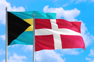 Denmark and Bahamas national flag waving in the windy deep blue sky. Diplomacy and international relations concept.