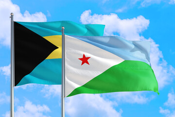 Djibouti and Bahamas national flag waving in the windy deep blue sky. Diplomacy and international relations concept.