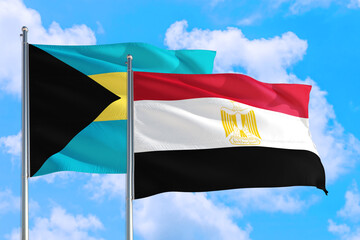 Egypt and Bahamas national flag waving in the windy deep blue sky. Diplomacy and international relations concept.