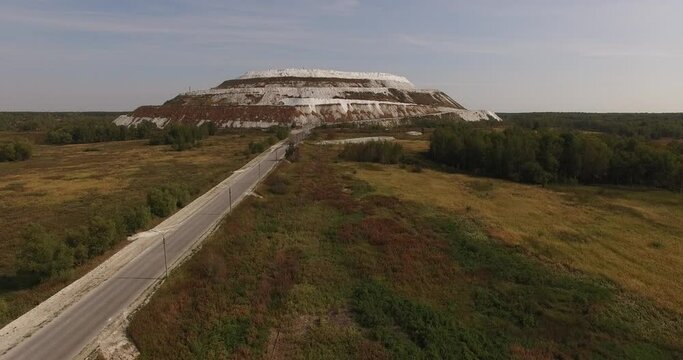 4K sunny morning aerial video of huge industrial phosphorite powder man made "White Mountain" near small town Voskresensk in Moscow Oblast near Moscow, Russia. Phosphorite is still mined there