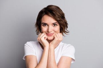 Photo of young brown hair attractive positive girl enjoy smile hands touch cheekbones isolated over grey color background