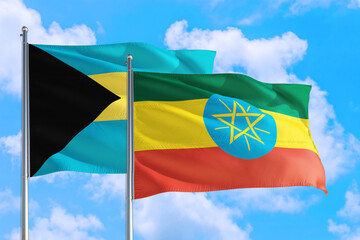 Ethiopia and Bahamas national flag waving in the windy deep blue sky. Diplomacy and international relations concept.