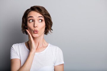 Portrait of young shocked surprised impressed girl woman female look in copyspace hold hands on cheek isolated on grey color background