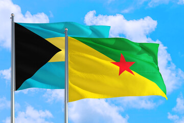 French Guiana and Bahamas national flag waving in the windy deep blue sky. Diplomacy and international relations concept.
