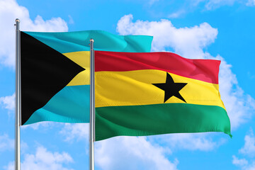 Ghana and Bahamas national flag waving in the windy deep blue sky. Diplomacy and international relations concept.