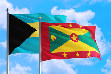 Grenada and Bahamas national flag waving in the windy deep blue sky. Diplomacy and international relations concept.