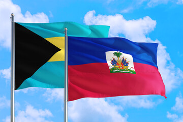 Haiti and Bahamas national flag waving in the windy deep blue sky. Diplomacy and international relations concept.