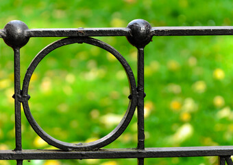 Fragment of cast-iron fence in the park - artistic metal casting.