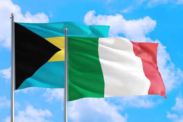 Italy and Bahamas national flag waving in the windy deep blue sky. Diplomacy and international relations concept.