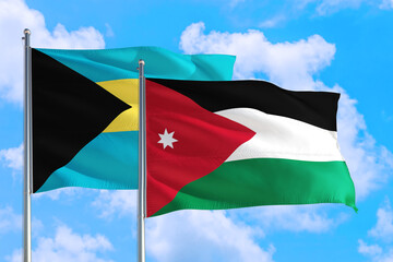 Jordan and Bahamas national flag waving in the windy deep blue sky. Diplomacy and international relations concept.