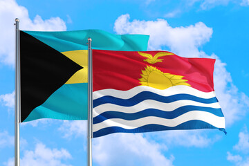 Kiribati and Bahamas national flag waving in the windy deep blue sky. Diplomacy and international relations concept.