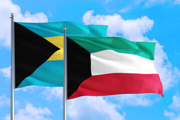 Kuwait and Bahamas national flag waving in the windy deep blue sky. Diplomacy and international relations concept.