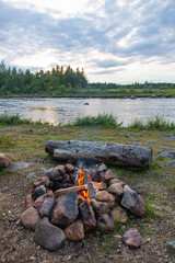 Campfire in camping on the bank of the Inari lake, active leisure in nature, Northern Finland
