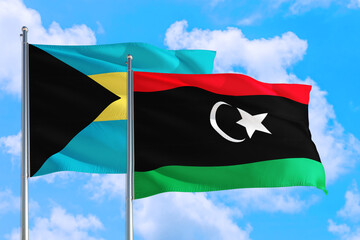 Libya and Bahamas national flag waving in the windy deep blue sky. Diplomacy and international relations concept.