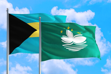 Macao and Bahamas national flag waving in the windy deep blue sky. Diplomacy and international relations concept.