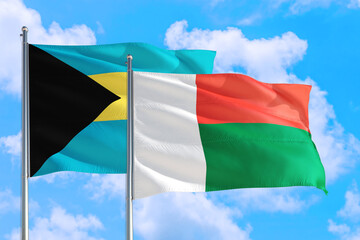 Madagascar and Bahamas national flag waving in the windy deep blue sky. Diplomacy and international relations concept.