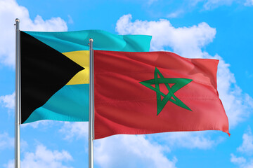 Morocco and Bahamas national flag waving in the windy deep blue sky. Diplomacy and international relations concept.