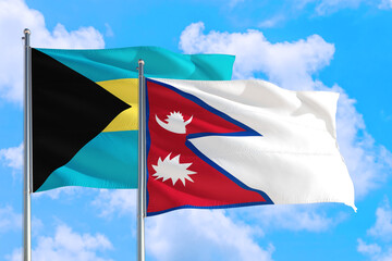 Nepal and Bahamas national flag waving in the windy deep blue sky. Diplomacy and international relations concept.
