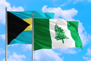 Norfolk Island and Bahamas national flag waving in the windy deep blue sky. Diplomacy and international relations concept.