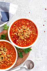 Vegetarian soup with vegetables, green peas, couscous (ptitim paste) and lentils on a grey table top view. Copy space for text. Maghreb soup berkoukes. North African cuisine.