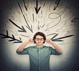 Irritated and annoyed man covering ears with fingers, looks displeased, refuses to listen gossips....