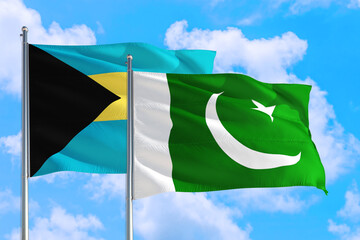 Pakistan and Bahamas national flag waving in the windy deep blue sky. Diplomacy and international relations concept.