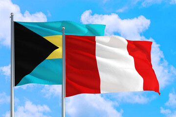 Peru and Bahamas national flag waving in the windy deep blue sky. Diplomacy and international relations concept.