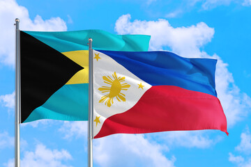 Philippines and Bahamas national flag waving in the windy deep blue sky. Diplomacy and international relations concept.