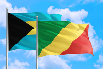 Republic Of The Congo and Bahamas national flag waving in the windy deep blue sky. Diplomacy and international relations concept.