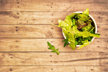 Lettuce in a bowl with a wooden background and copy space