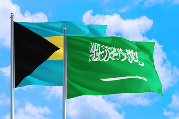 Saudi Arabia and Bahamas national flag waving in the windy deep blue sky. Diplomacy and international relations concept.