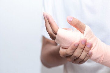 Close-up of a man hand wrapping elastic bandage. Wounded hand cover with bandage.