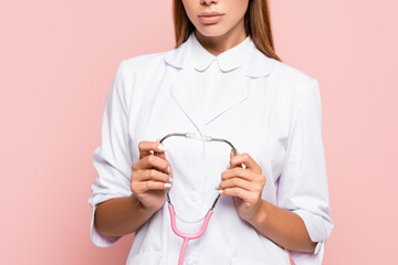 Cropped view of doctor holding stethoscope isolated on pink