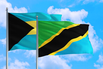 Tanzania and Bahamas national flag waving in the windy deep blue sky. Diplomacy and international relations concept.