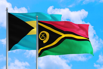 Vanuatu and Bahamas national flag waving in the windy deep blue sky. Diplomacy and international relations concept.
