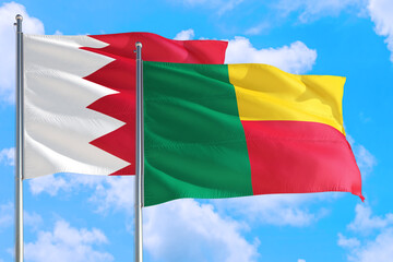 Benin and Bahrain national flag waving in the windy deep blue sky. Diplomacy and international relations concept.