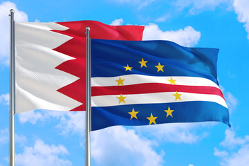 Cape Verde and Bahrain national flag waving in the windy deep blue sky. Diplomacy and international relations concept.