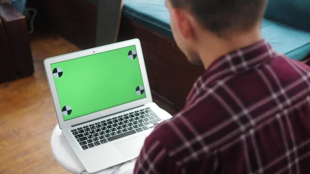Close-up of hipster freelancer male hands using green screen chroma key laptop typing working in light office with modern computer. Ready for motion design high quality 4k footage.